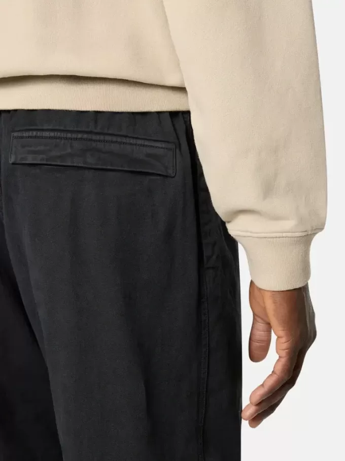 Weit geschnittene Jogginghose mit Druckknopf- und Reißverschlusstaschen Weit geschnittene Jogginghose mit Druckknopf- und Reißverschlusstaschen